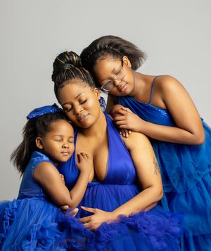 A tender moment captured in royal blue fabric as two people embrace in an artistic portrait series.