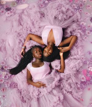 Ethereal pink floral backdrop creates dreamy setting for artistic portrait photography session.