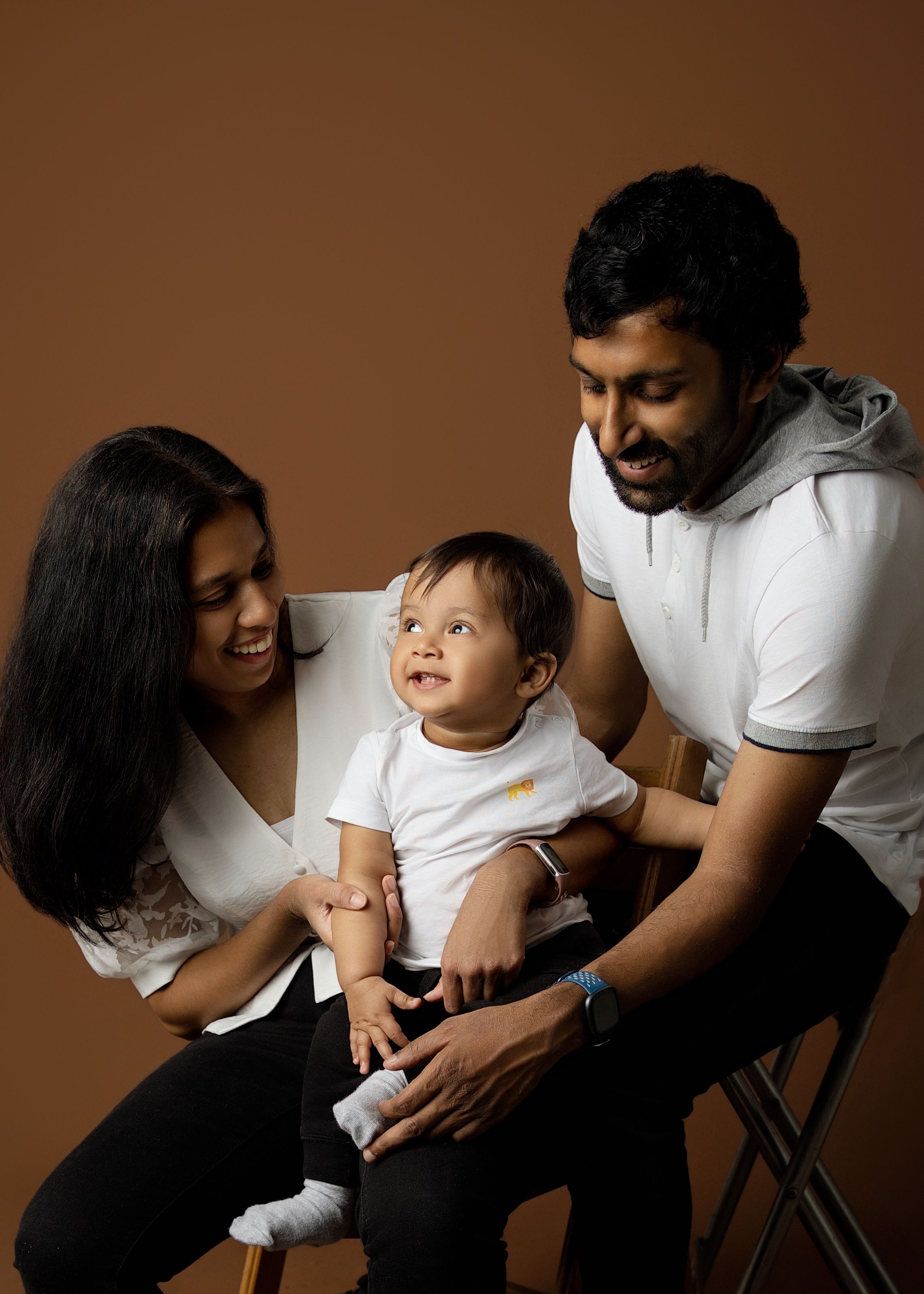 A heartwarming sequence of candid family moments captured against a brown backdrop showing parent-child interactions.