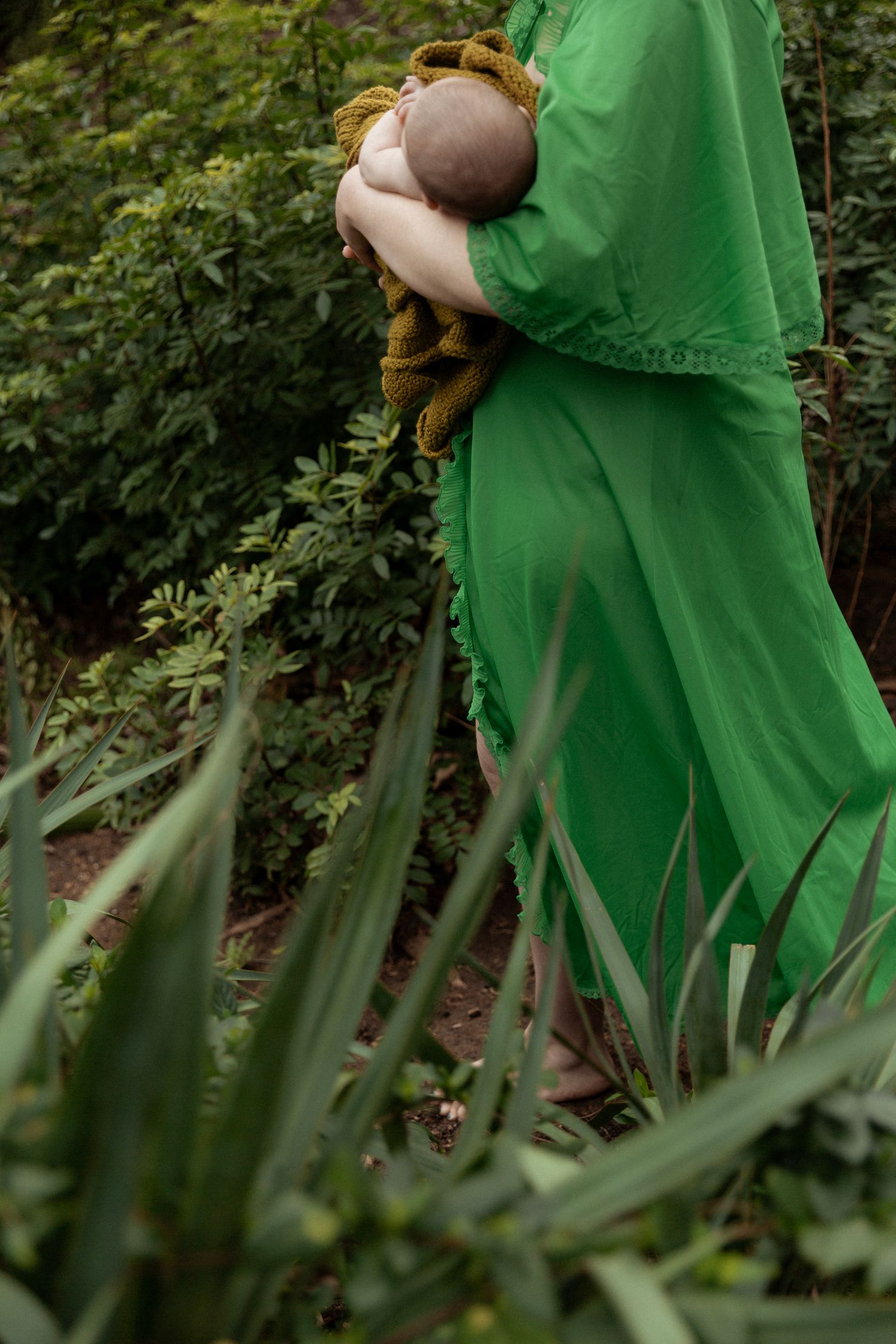 Flowing green fabric against natural garden foliage.