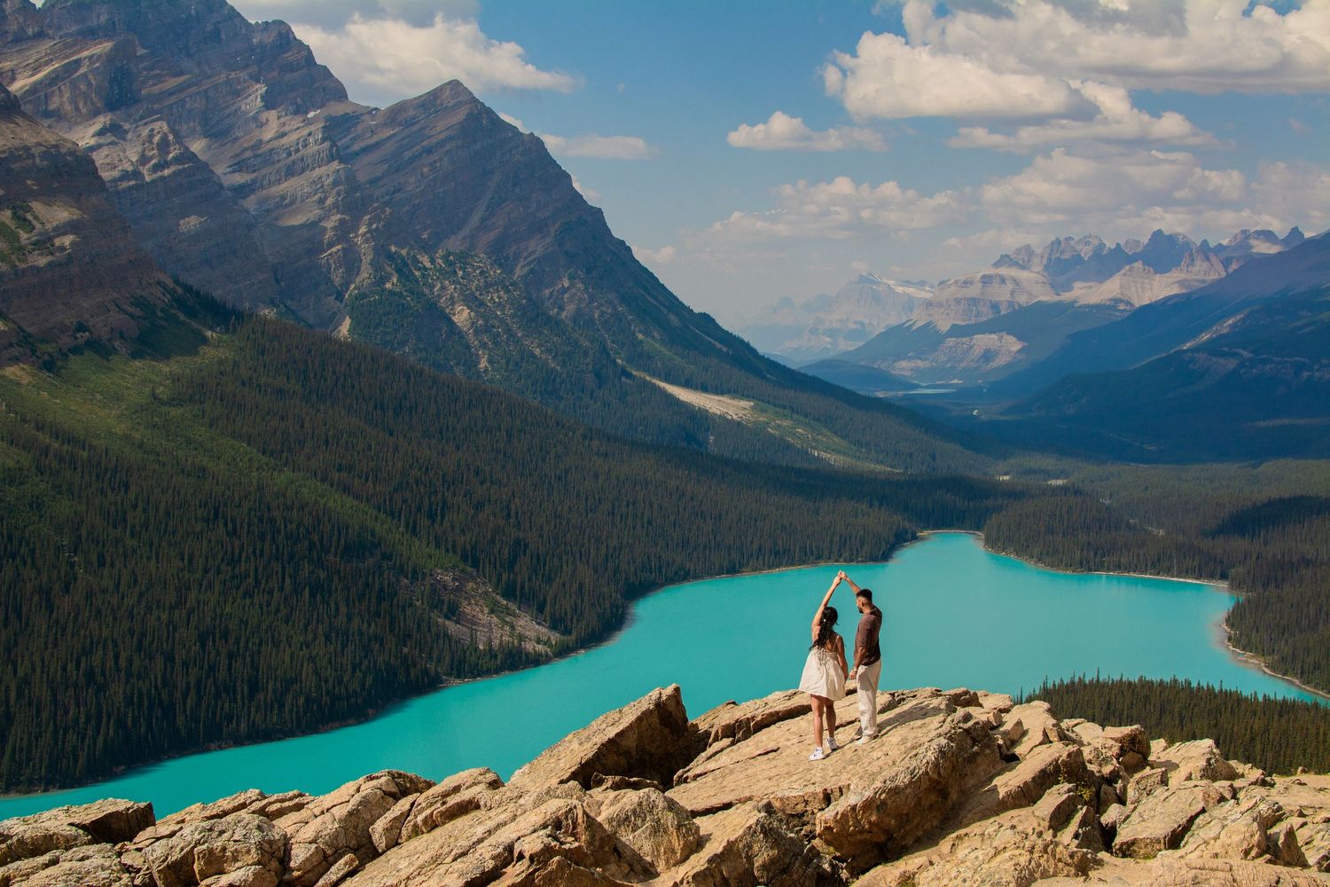 A couple poses at night in front of Peyto Lake, wolf head lake in Banff. Engagement session, proposal moment, at the secret second lookout