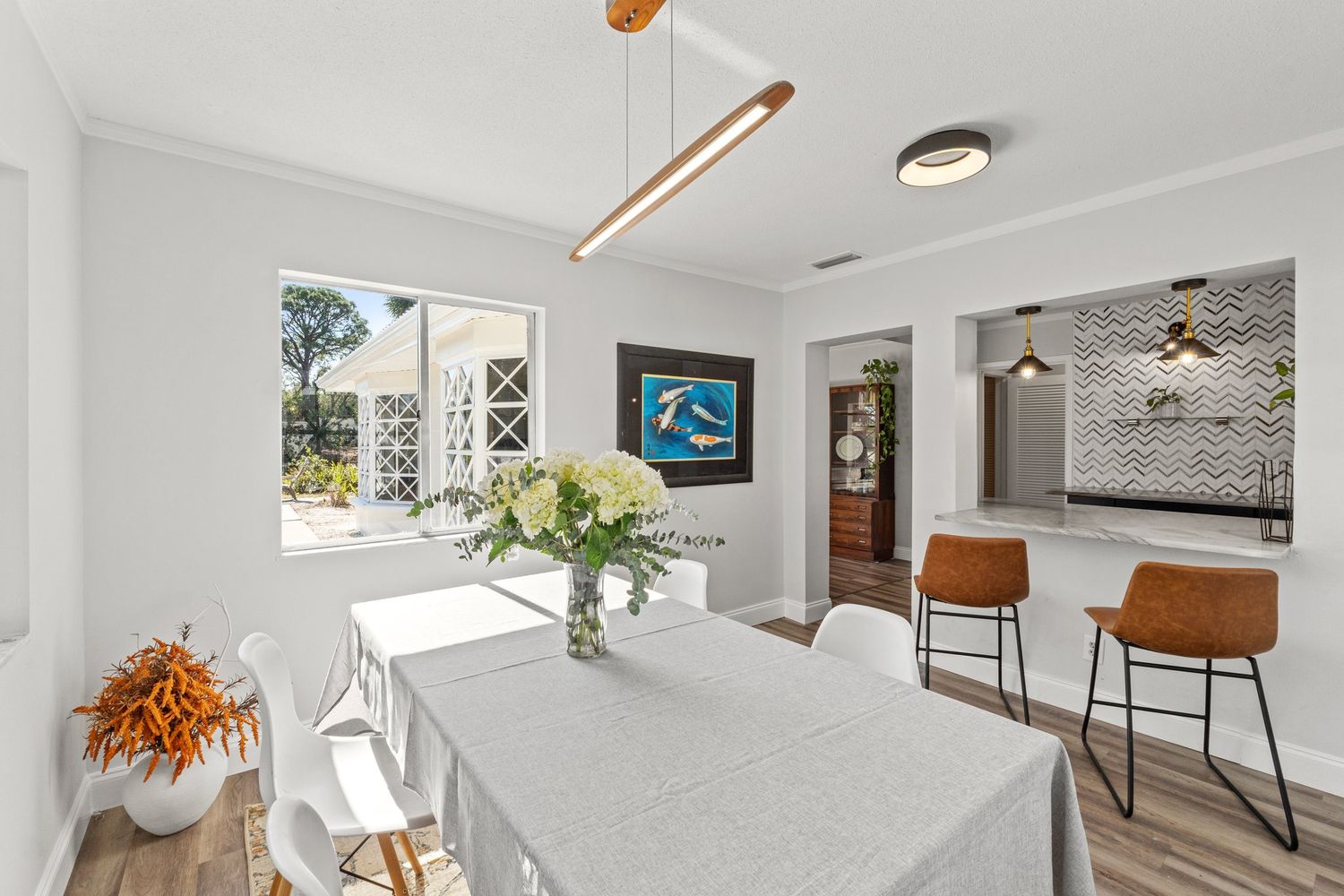 Bright modern interior with white walls, hardwood floors and large windows providing natural light.