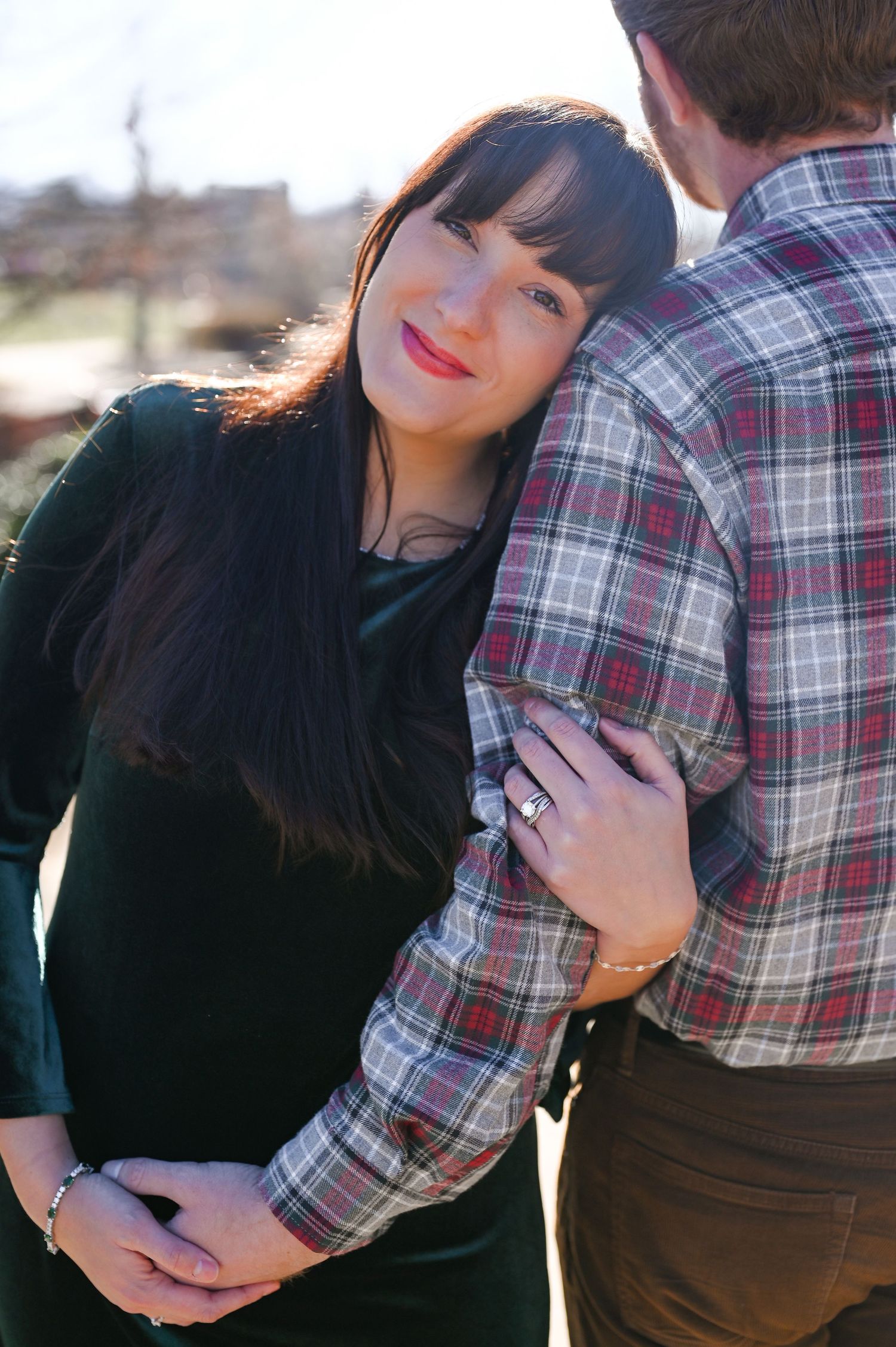 Romantic couple embracing outdoors during engagement photo session.