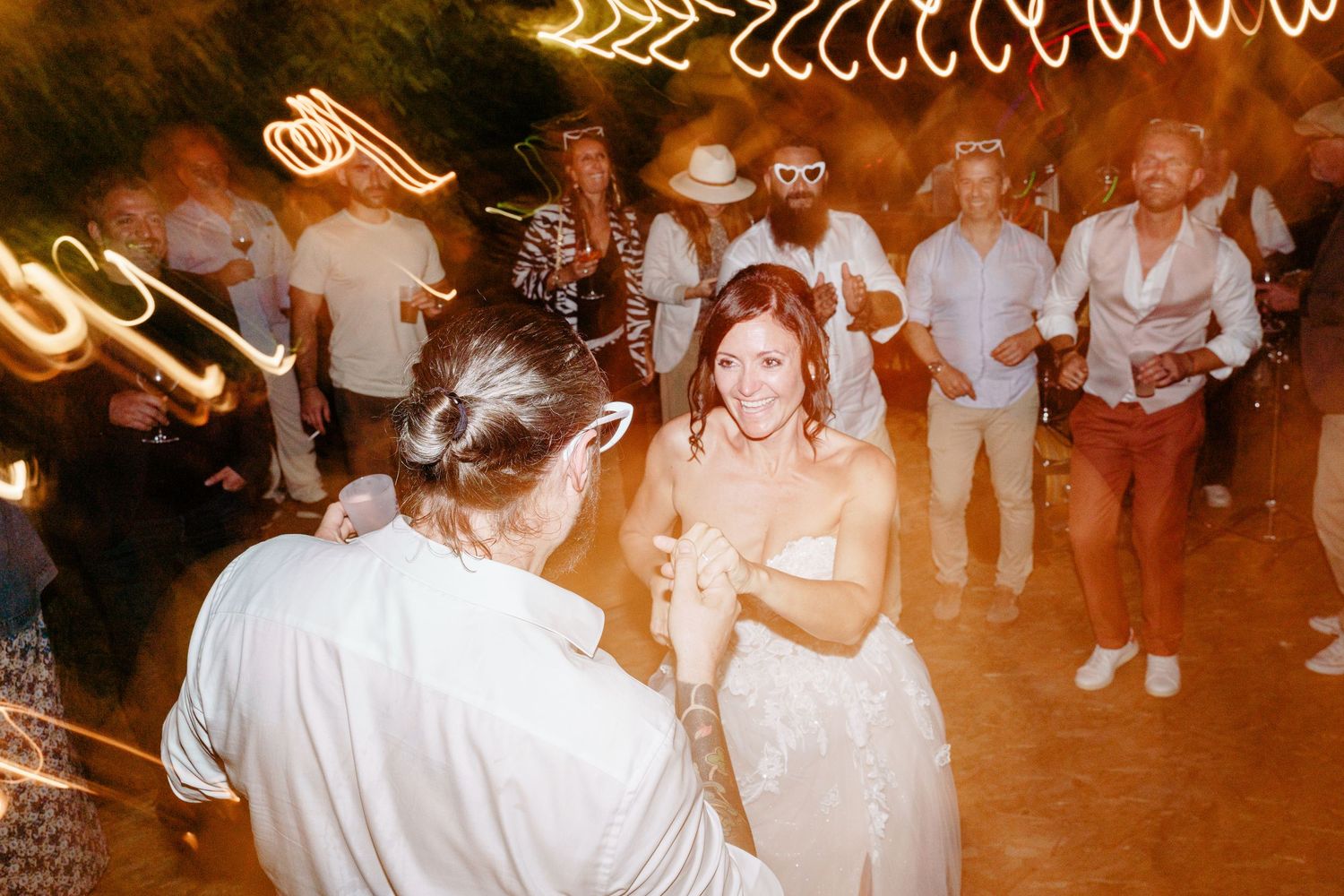Evening party with live music, dancing, and heart-shaped glasses glowing under the lights.