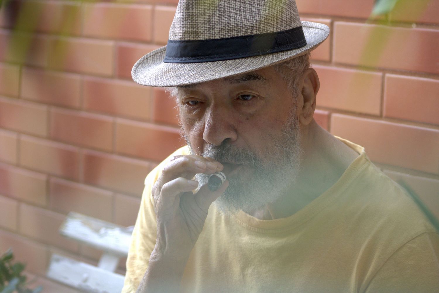 Natural light portrait of elderly man wearing hat outdoors, photographed by Piret Victoria Ribas.