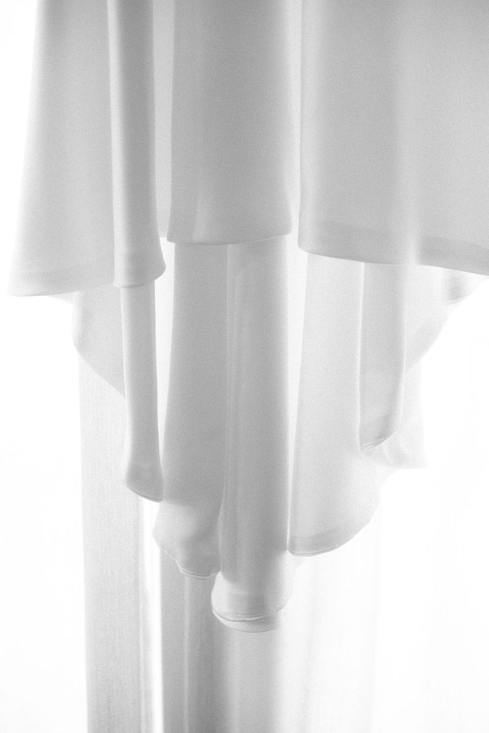 Elegant white wedding dress fabric flowing in minimal composition.