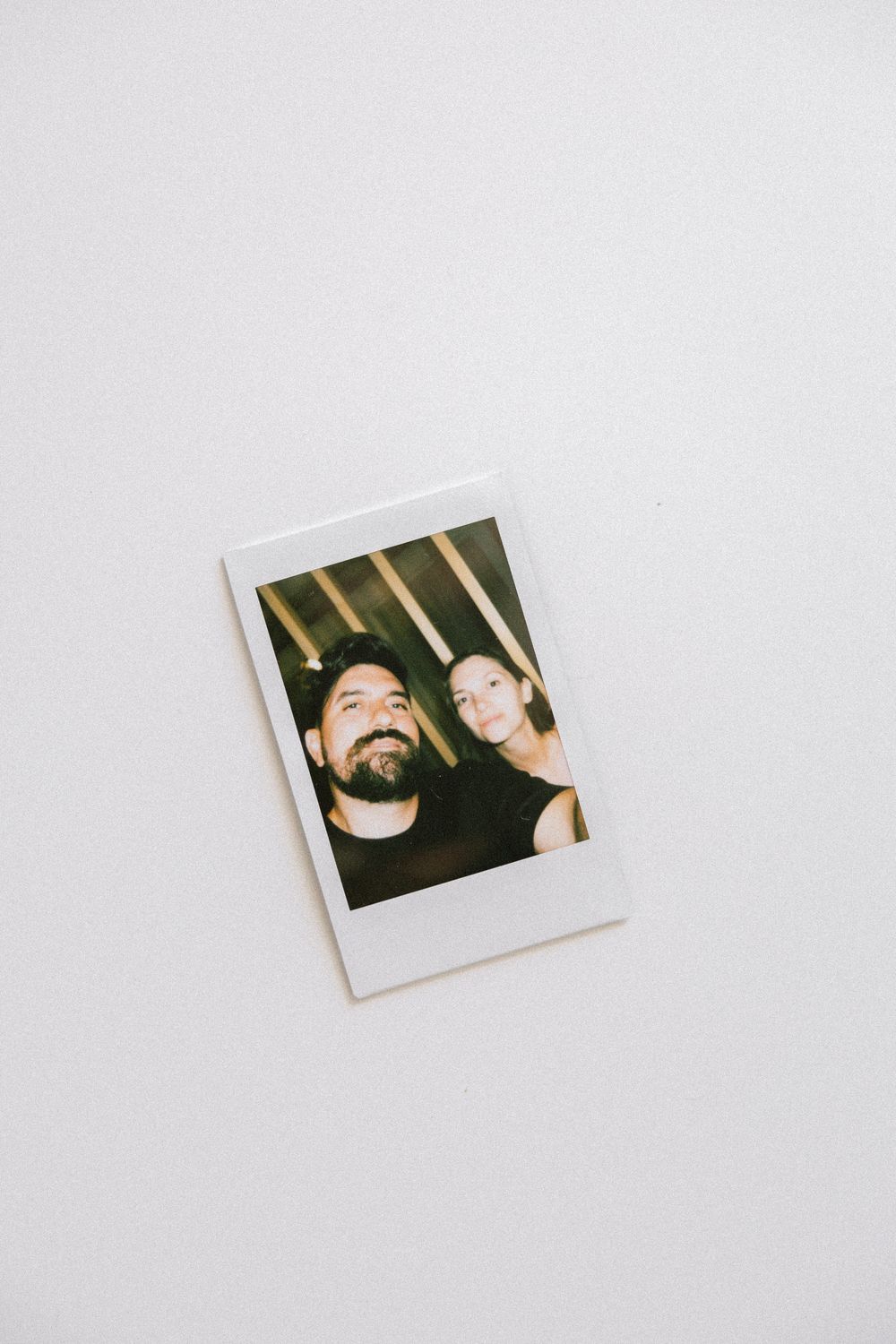 Close-up polaroid photo of couple on white background.