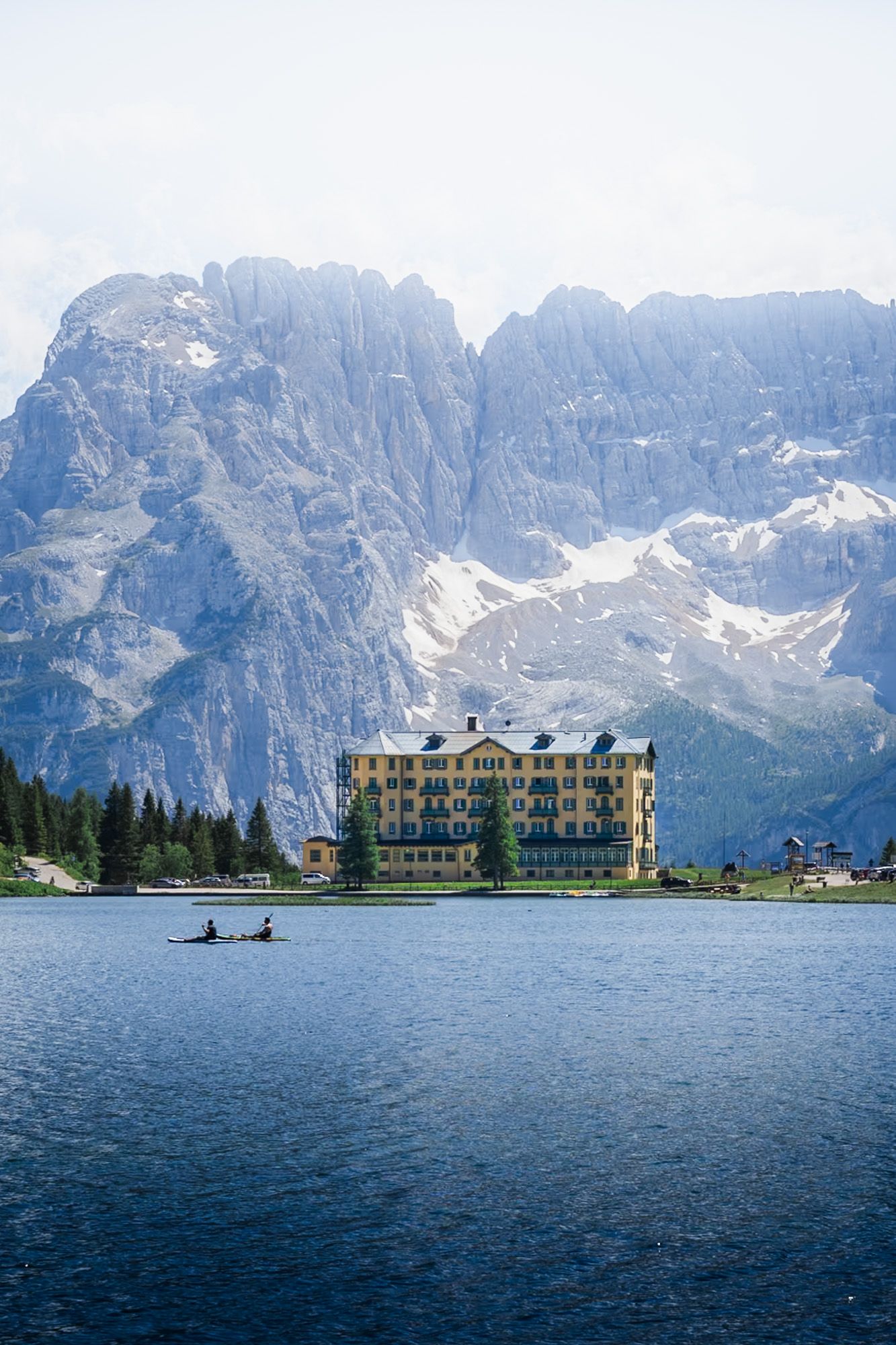 lago di misurina avec un hotel et des gens qui font du kayak dans les dolomites