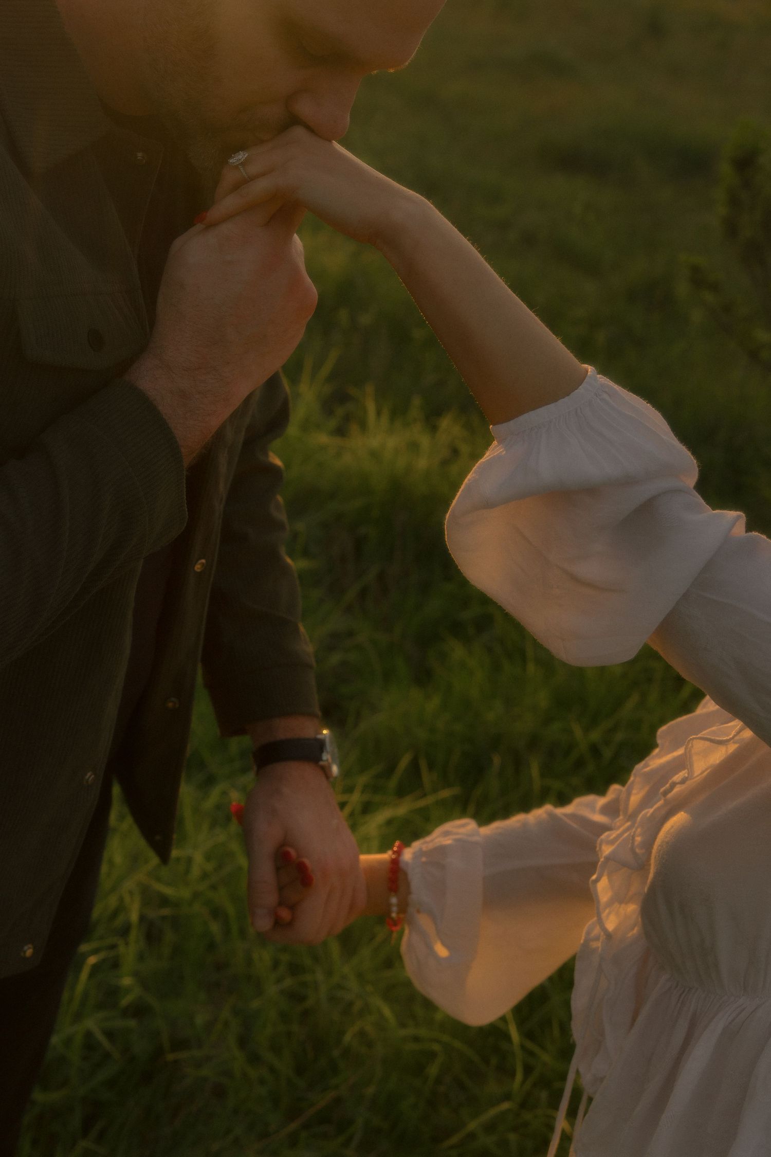 A series of hands pouring a warm glowing liquid into a cup at sunset in a grassy outdoor setting.