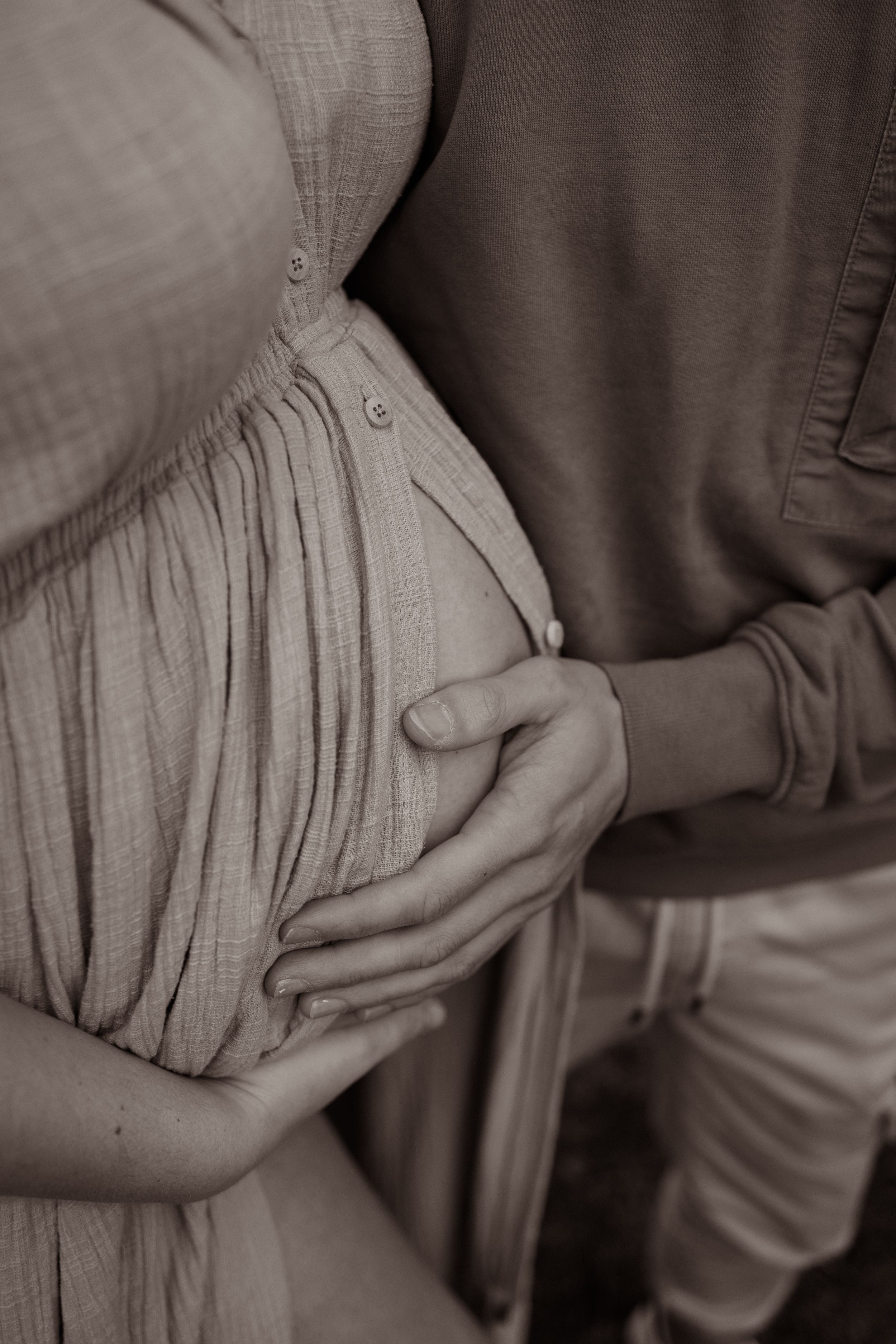 A series of black and white photos showing hands gently holding and caressing a textured fabric surface.