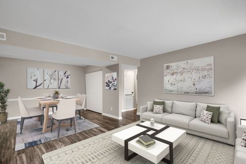 Modern apartment interior with neutral gray tones featuring living room, dining area and open concept design.