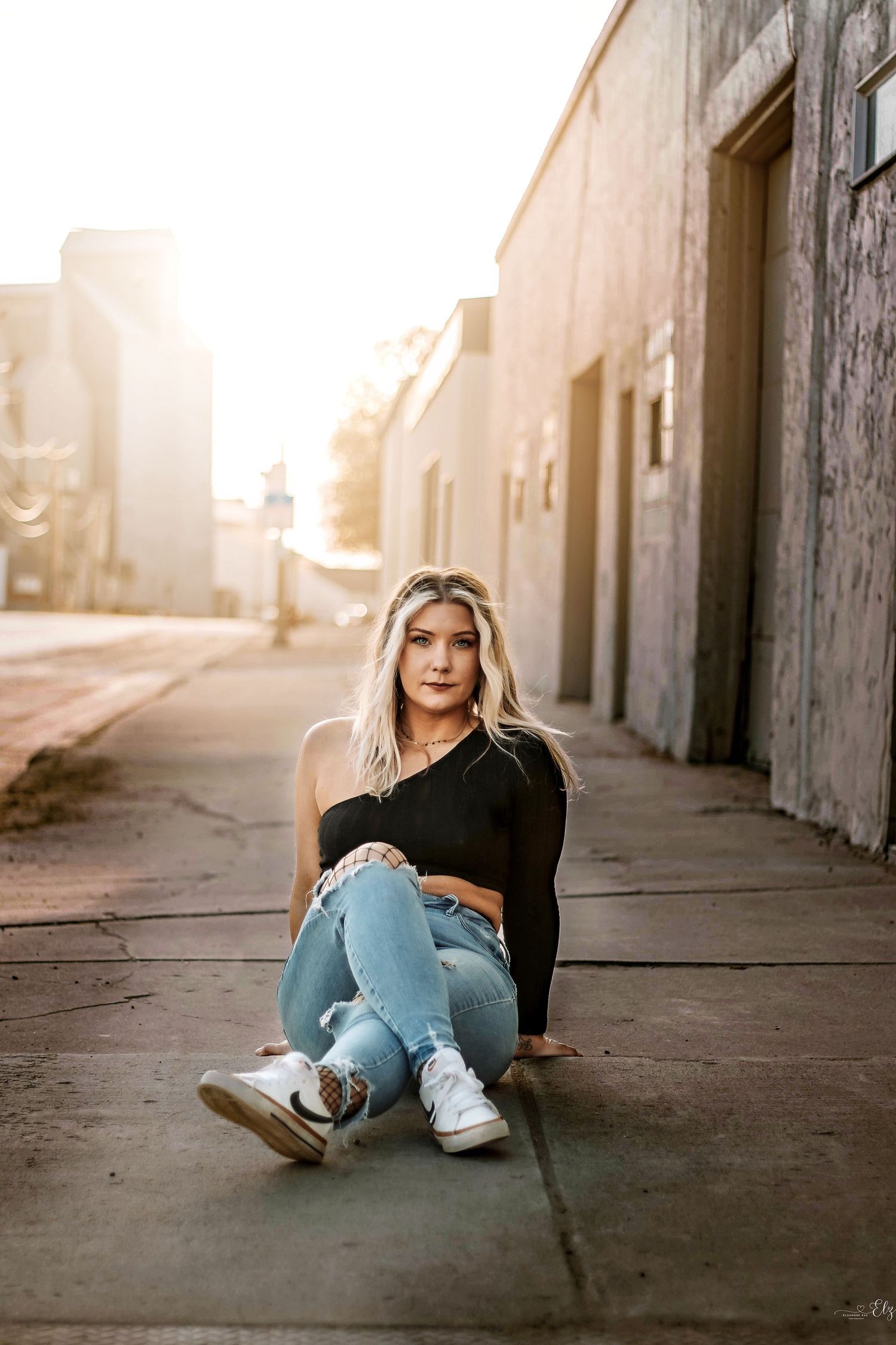 Urban photoshoot featuring casual poses on concrete walkway during golden hour in Williston, North Dakota.