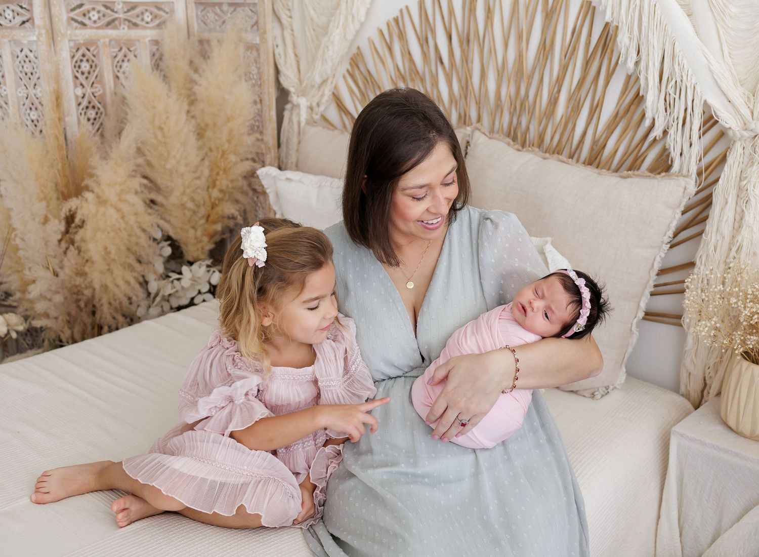 Maternity lifestyle session with pampas grass and natural decor elements.