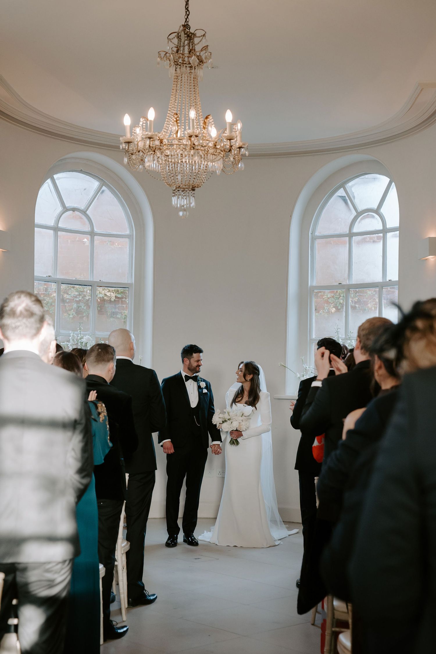 bride and groom stood at the alter smiling at each other at Iscoyd park