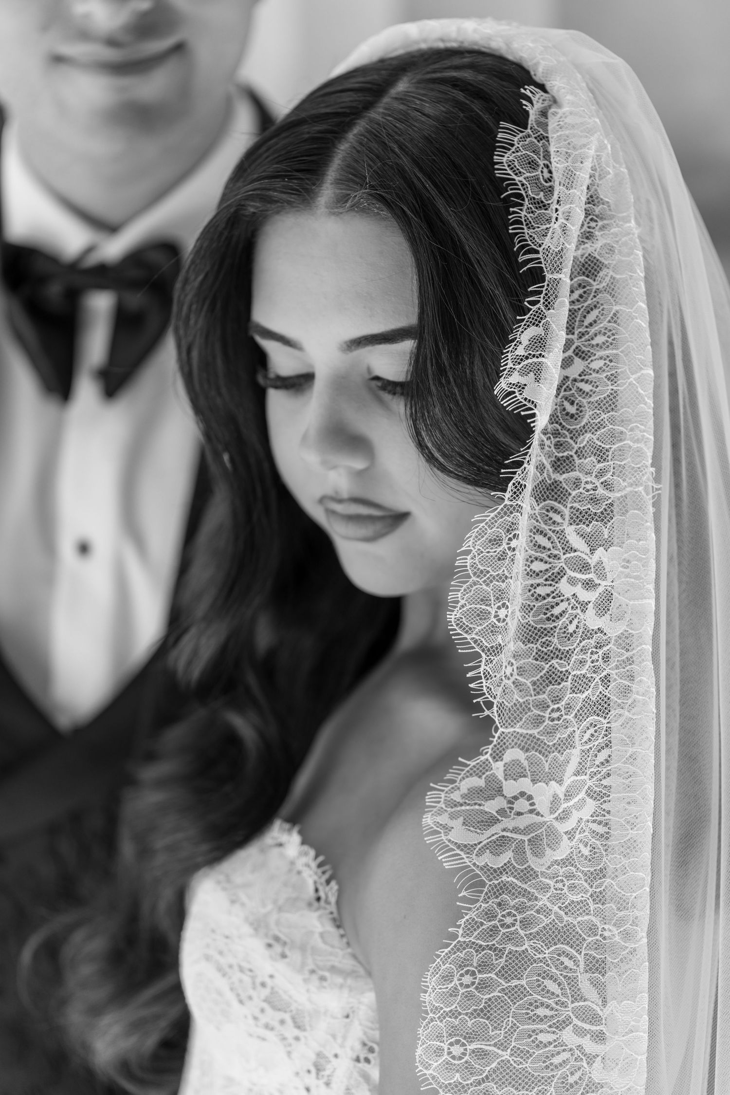 A couple dancing together at a wedding reception, with the bride wearing an elegant white fitted dress.