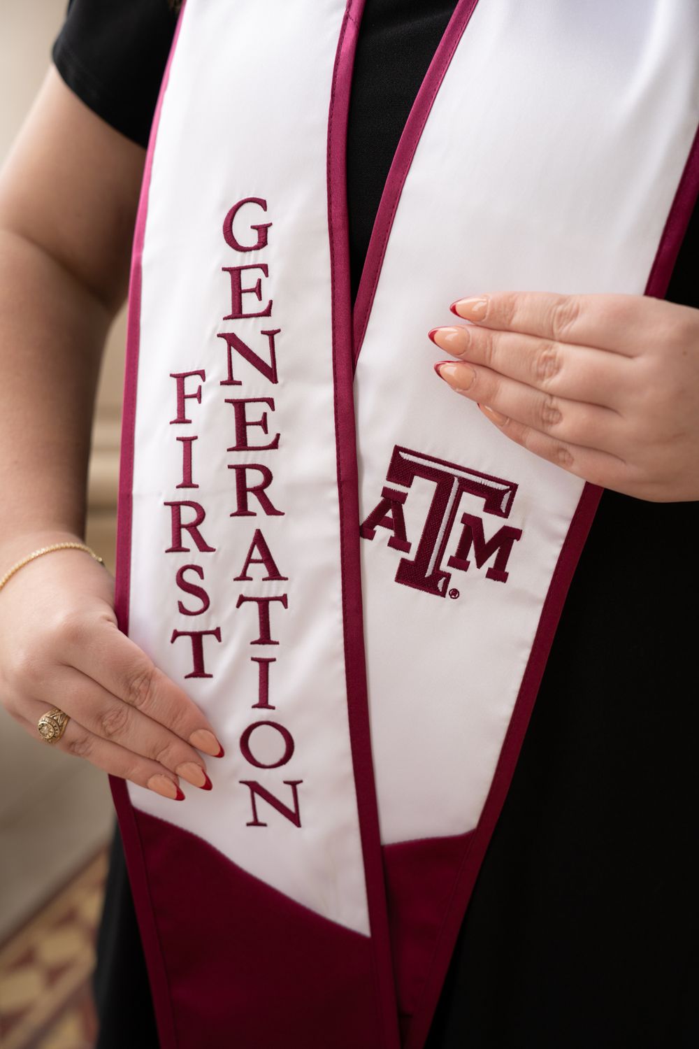 Close up of a maroon and white Texas A&M First Generation graduation stole featuring the university logo.
