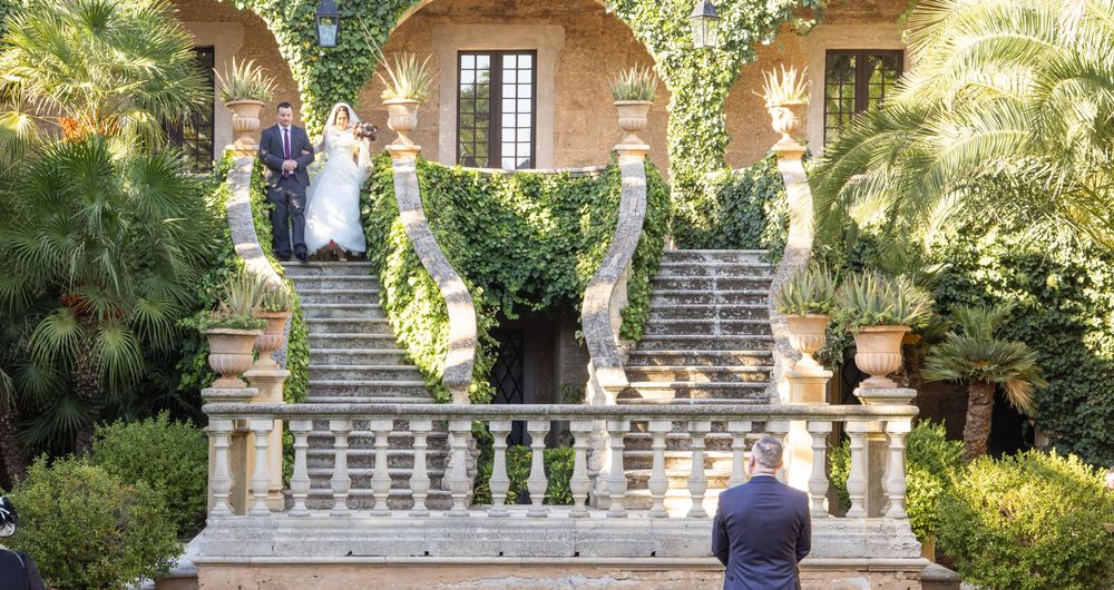 Bride walks down historic grand garden staircase at Castello Monaci, Puglia, Italy