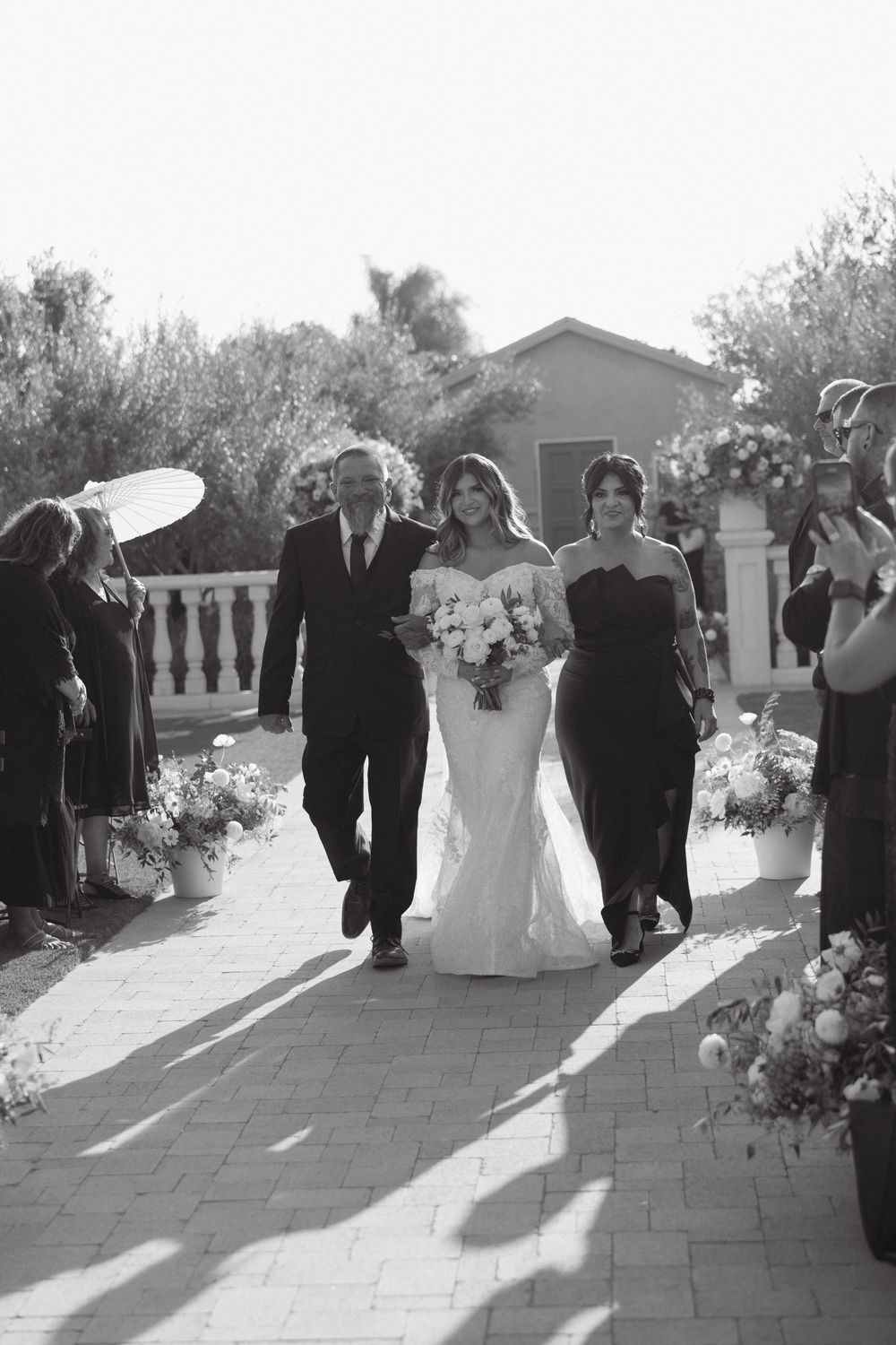 Bride walking down the aisle with her parents at Tuscan Rose Ranch wedding in Santa Paula, California
