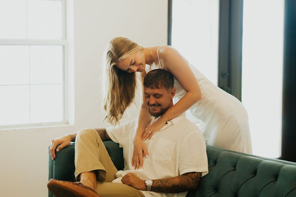An intimate indoor photoshoot with soft lighting and romantic atmosphere.