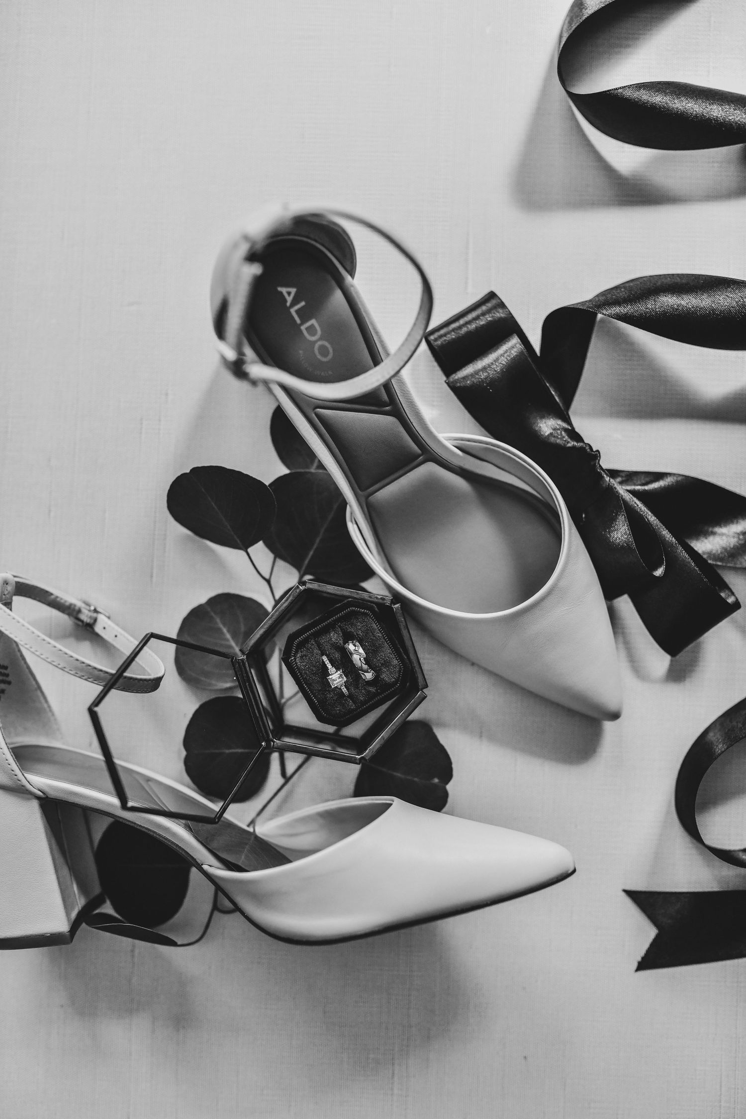 Wedding detail flat lay featuring invitations, jewelry, and thoughtfully styled accessories