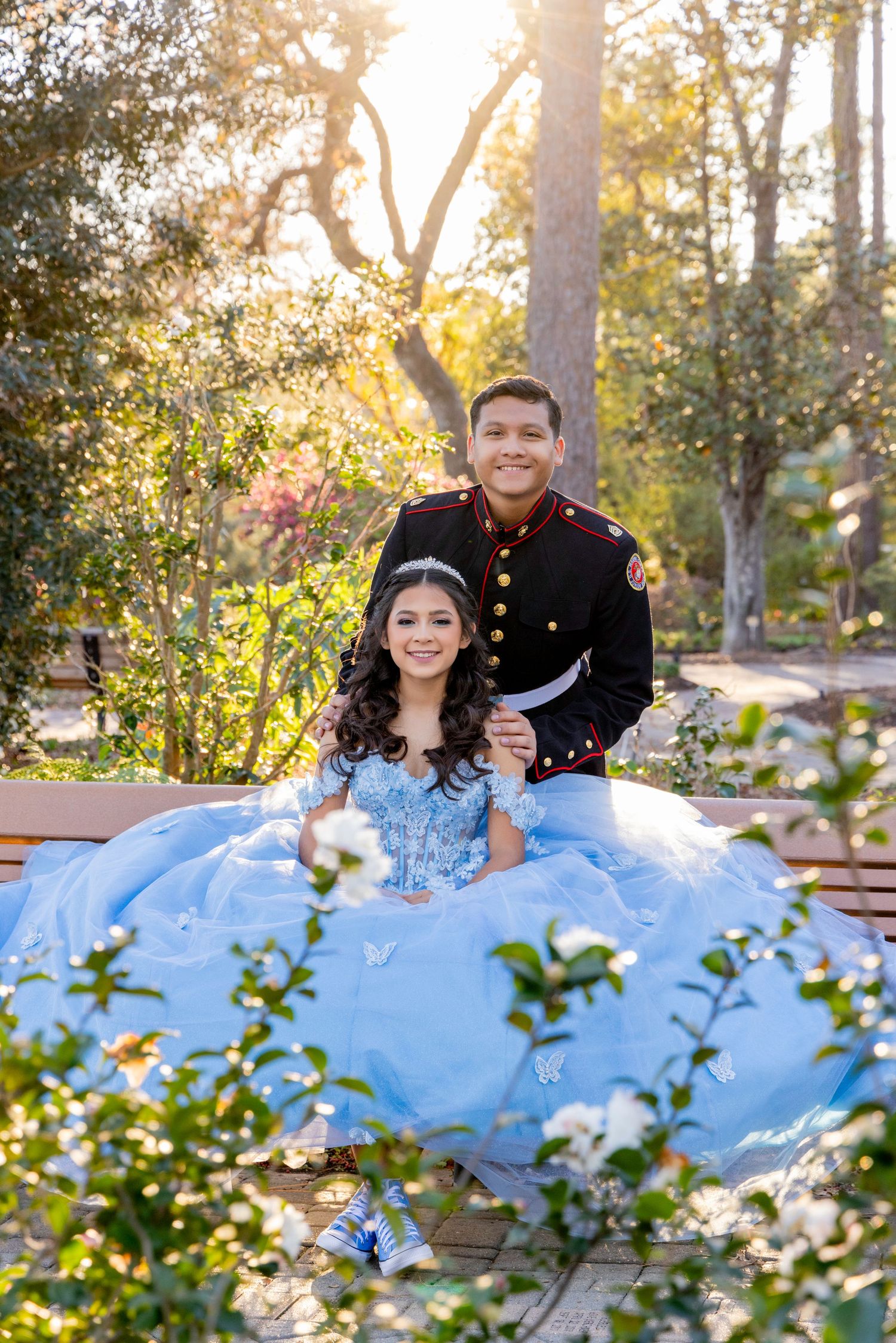 Romantic outdoor photoshoot featuring flowing blue dress against garden backdrop.