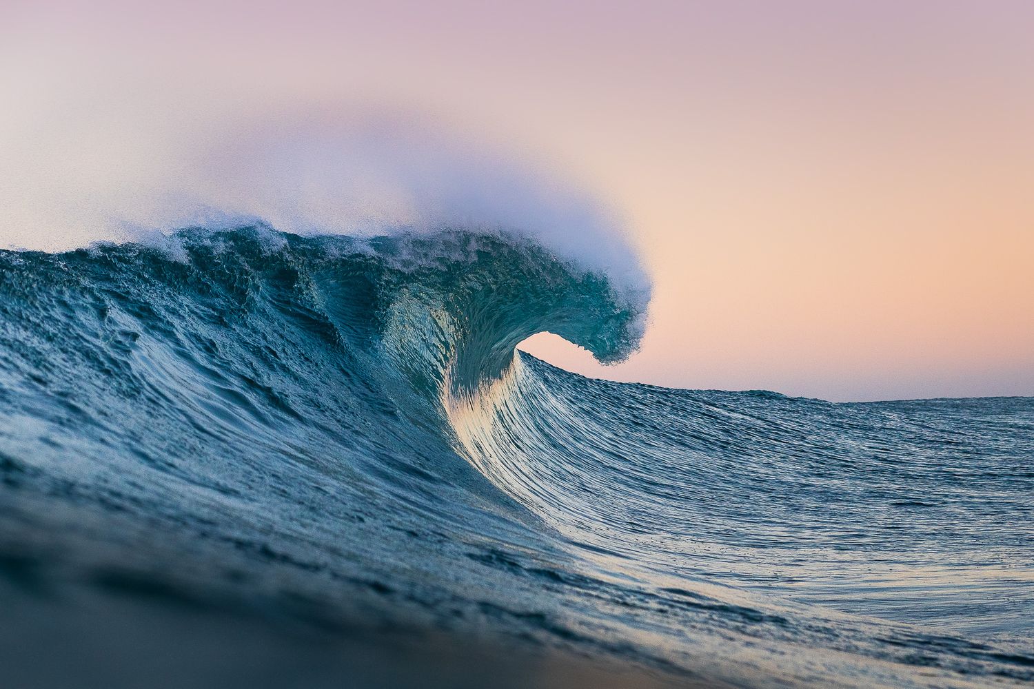 Ocean waves curl and break during a vibrant sunset creating a mesmerizing seascape view.