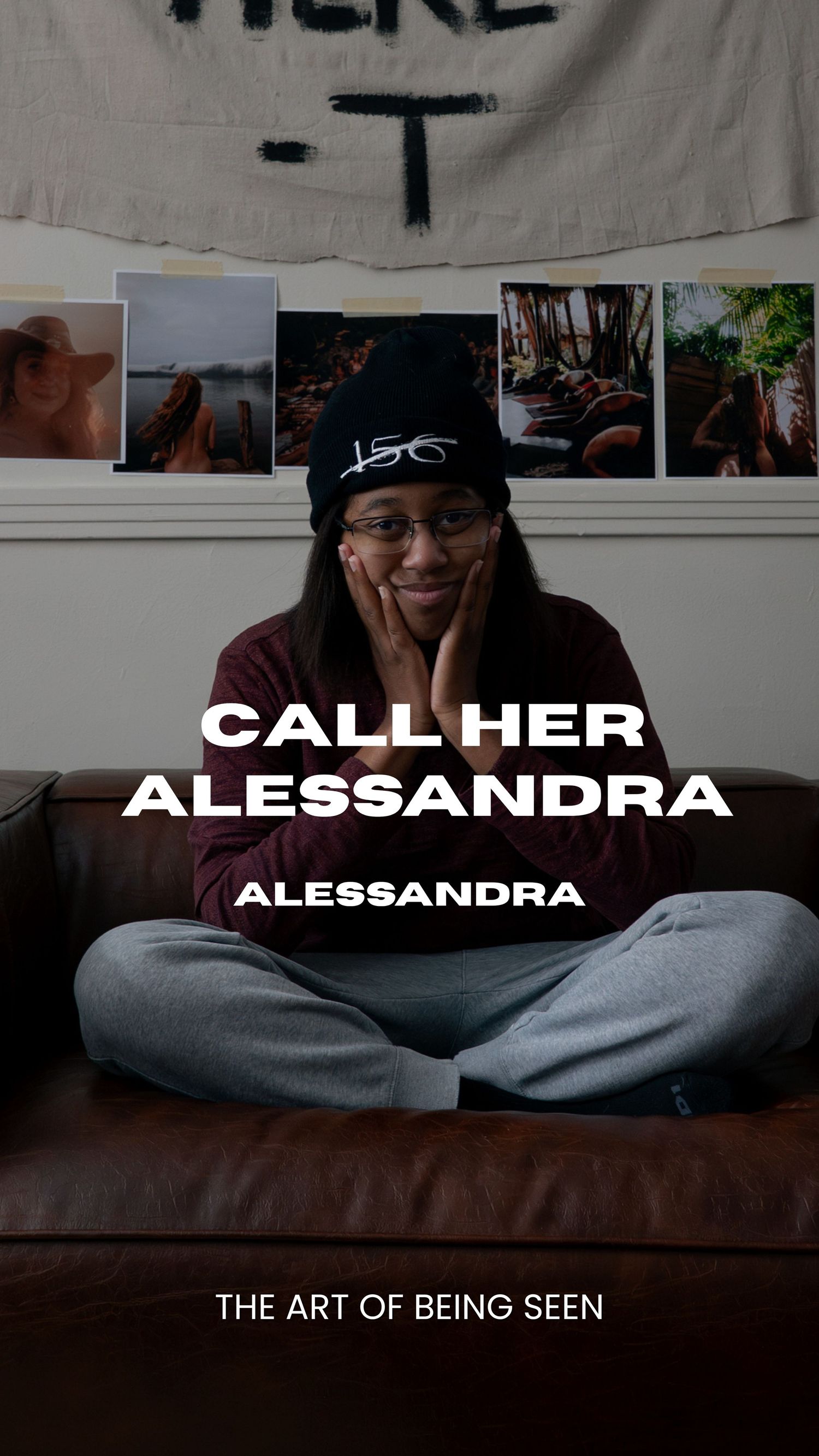 A cozy room with a brown couch, white walls covered in photographs, and a banner displaying 'THANK YOU FOR BEING HERE'.