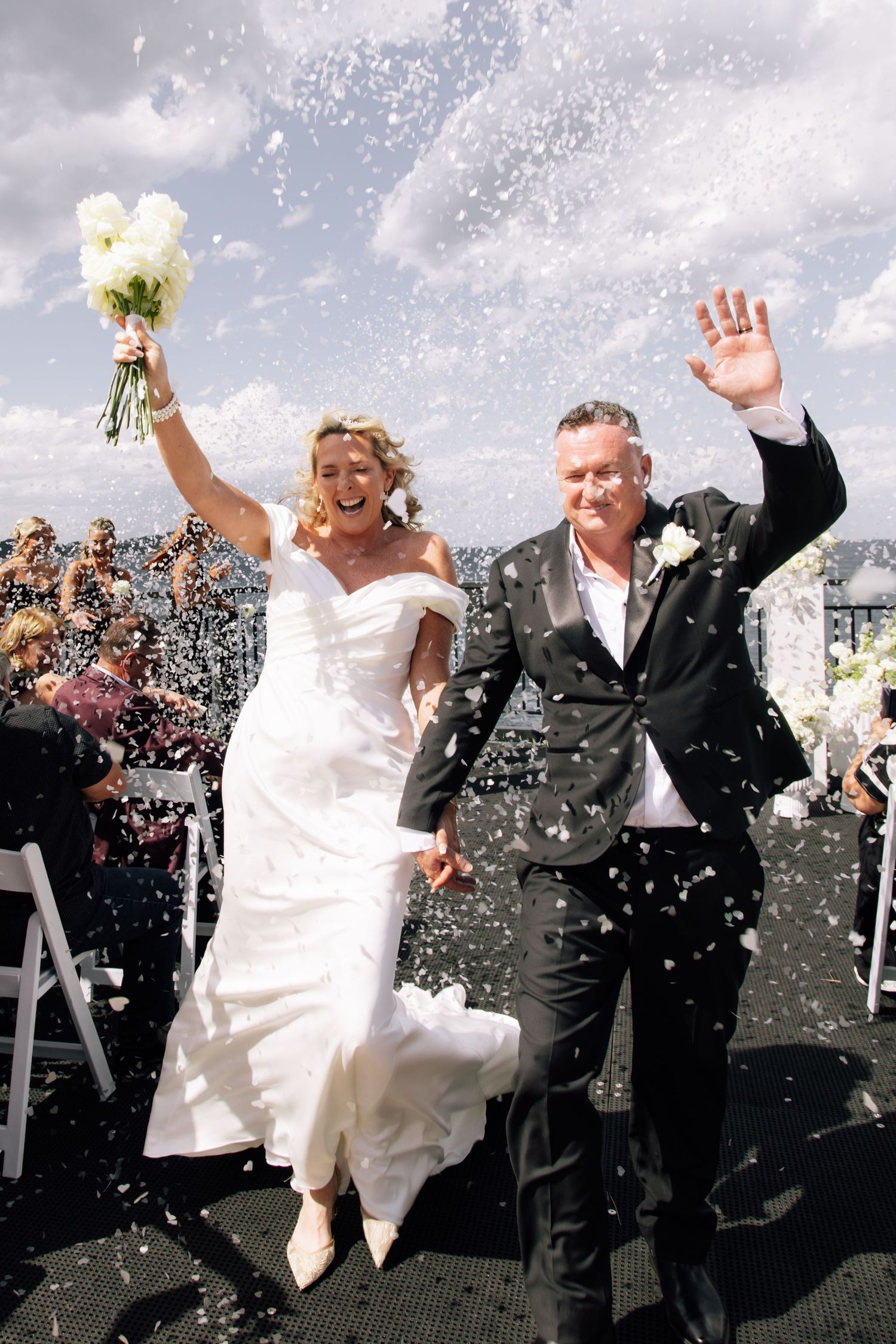 Wedding celebration sequence shows newlyweds jumping and celebrating amid falling confetti on their special day.