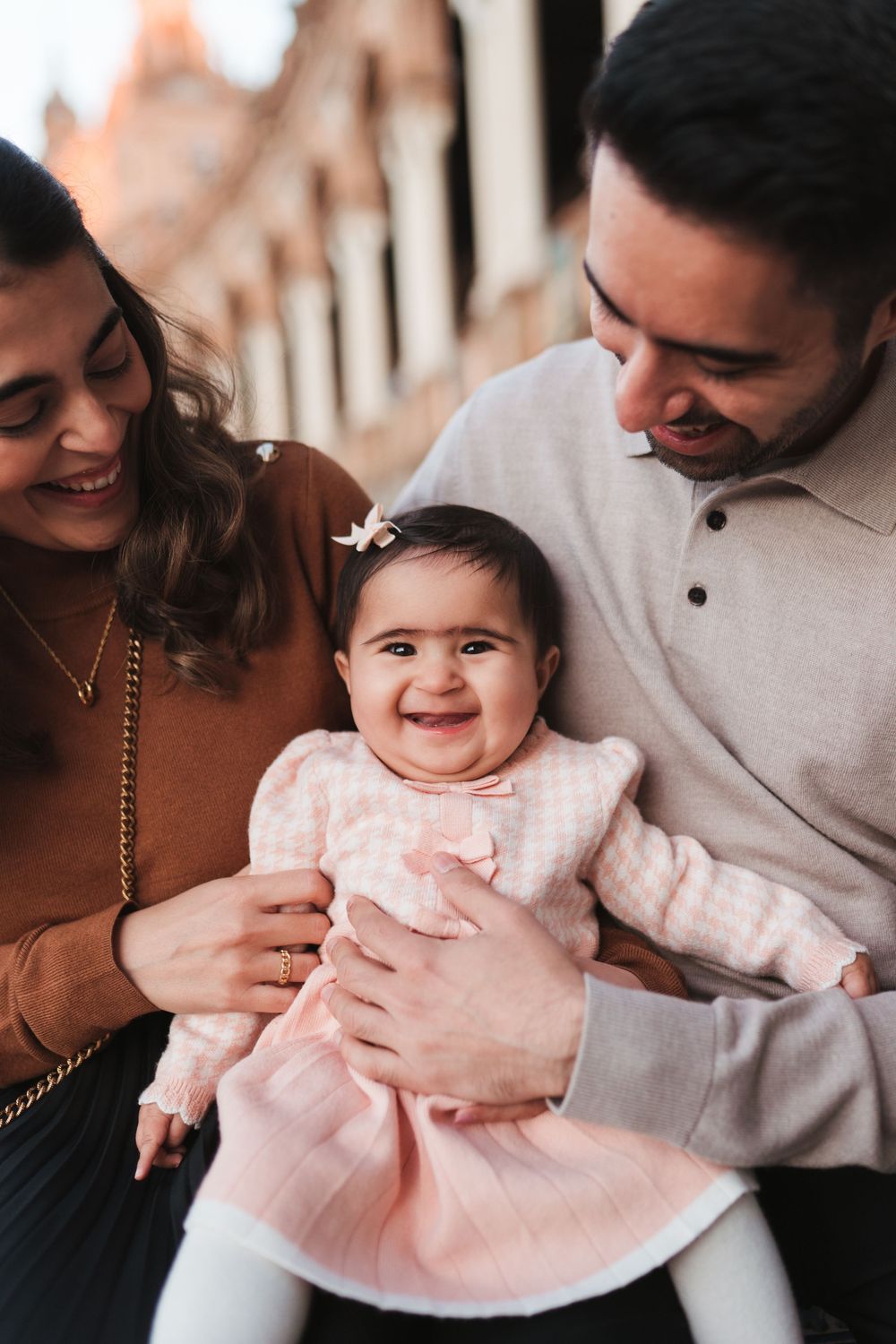 Happy family moment shared against decorative Spanish colonial architecture.