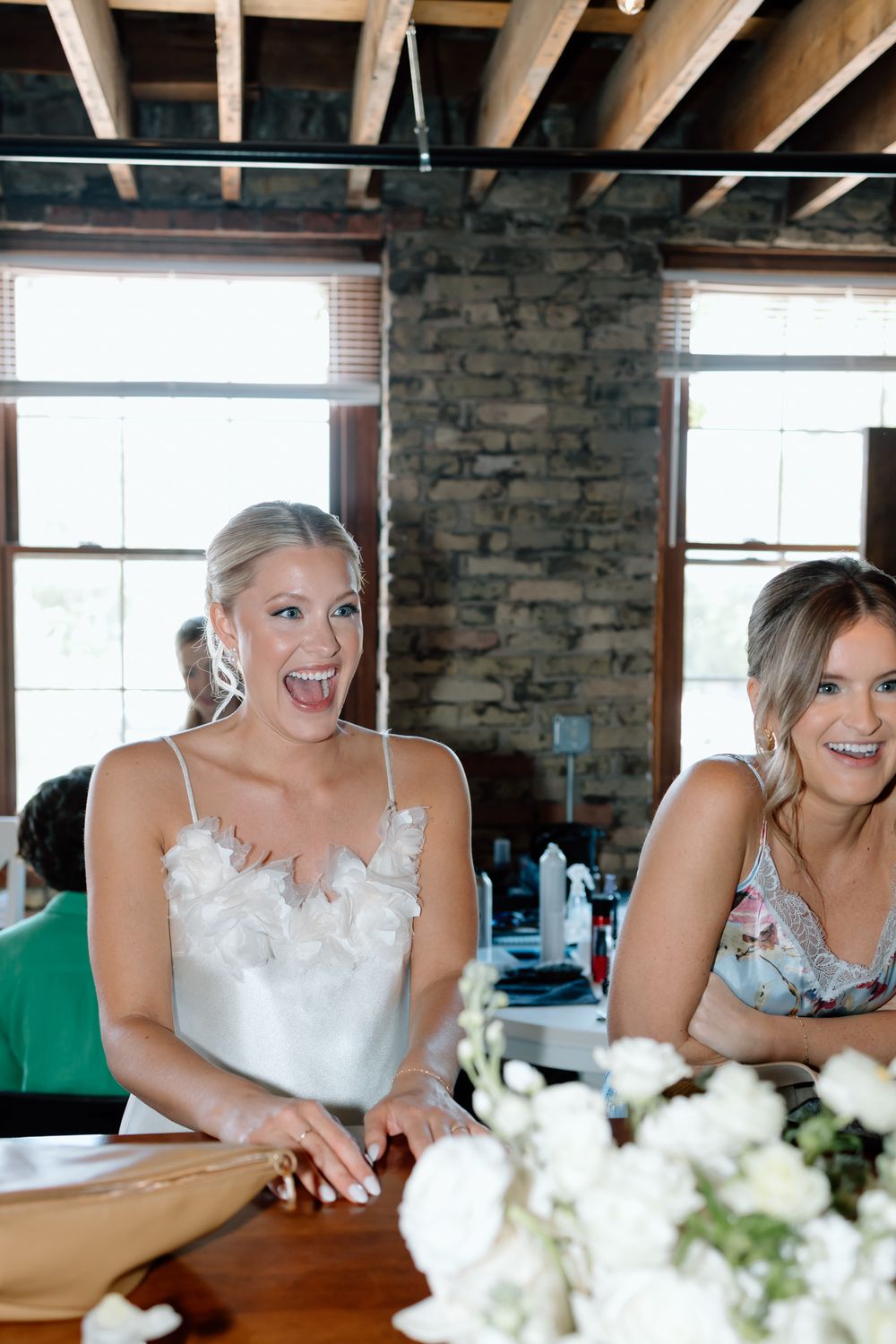 Wedding celebration at rustic venue with exposed brick walls and wooden beams.