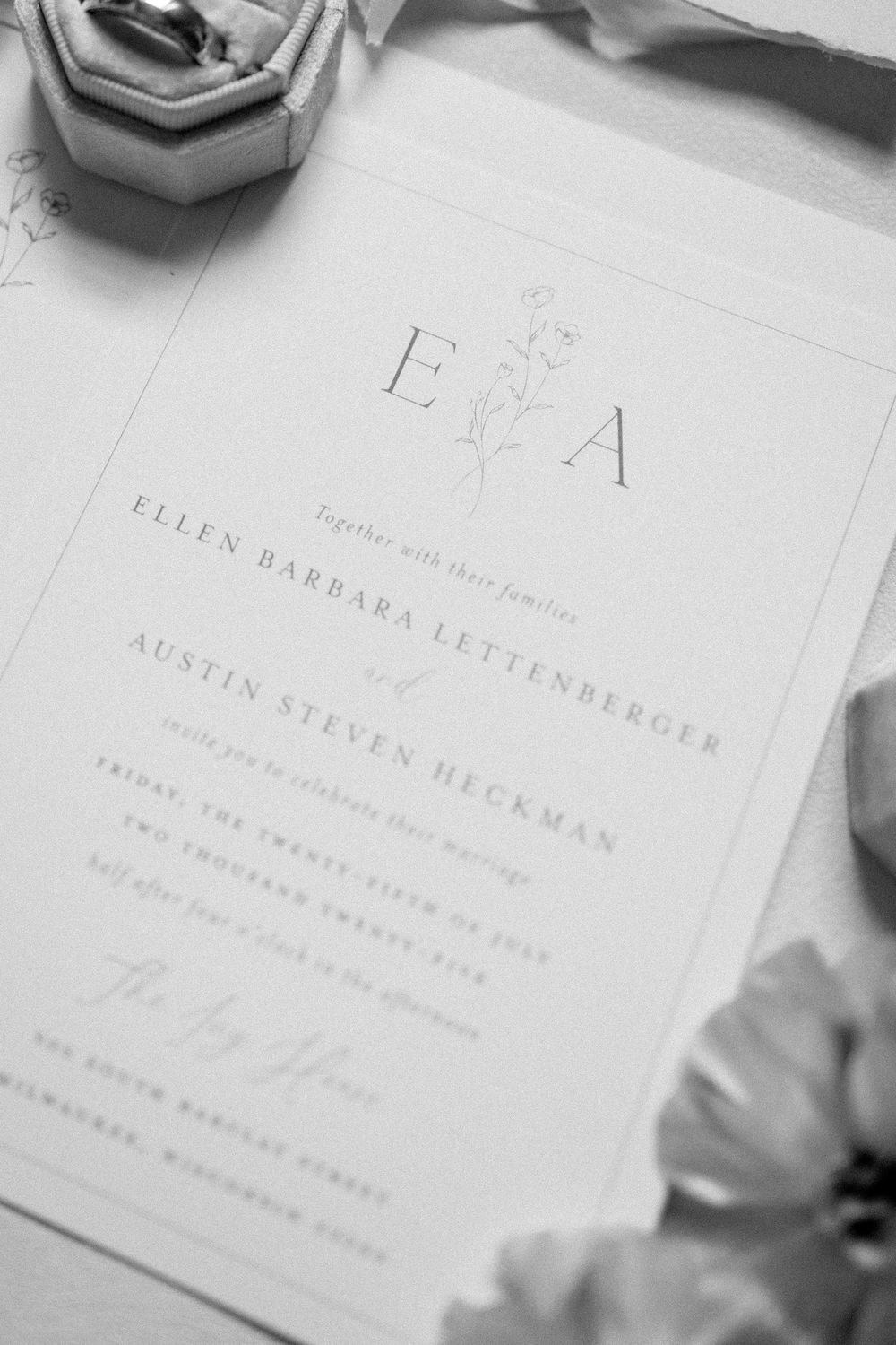 Wedding invitation details shown in elegant typography on white paper.