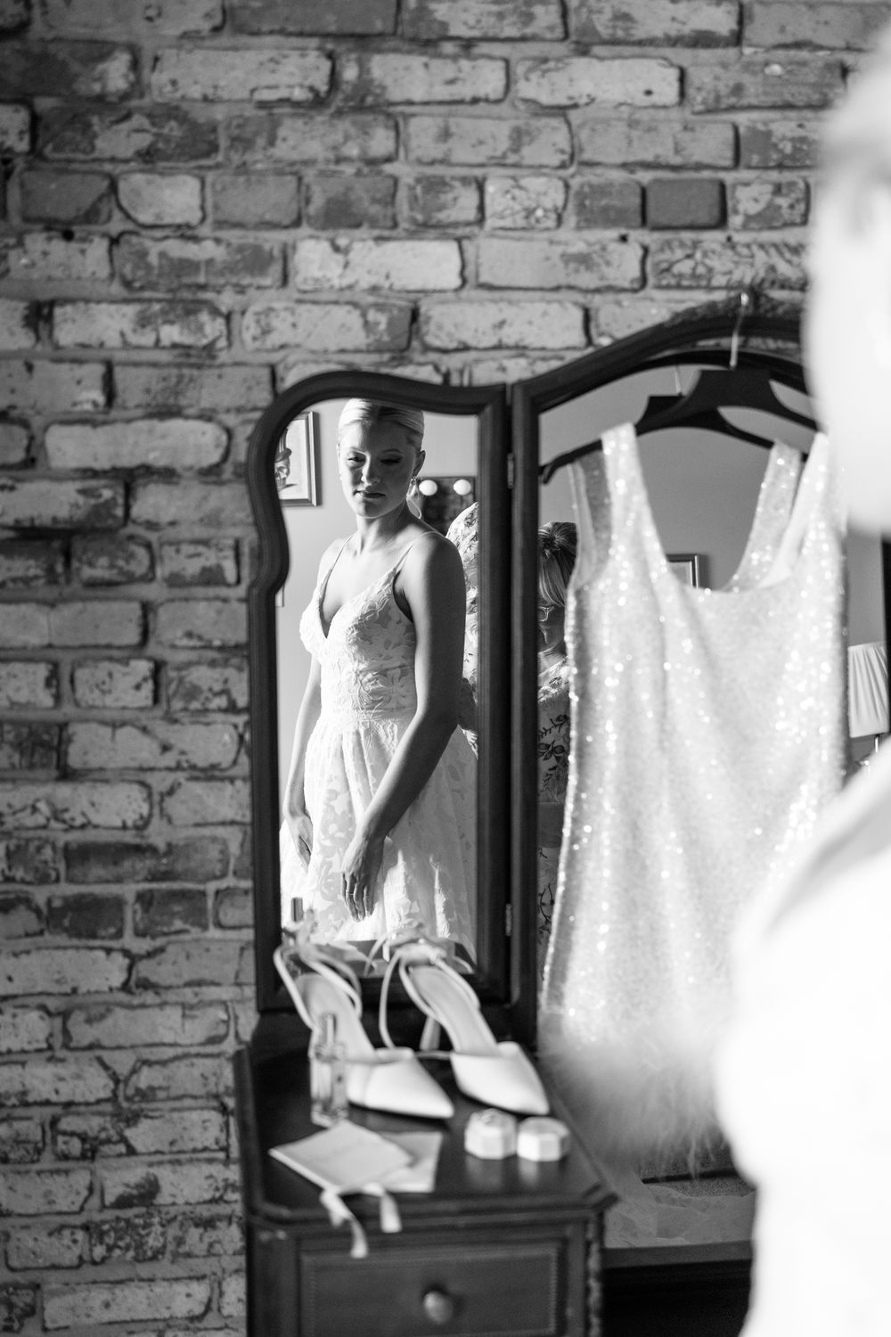 Wedding dress preparations in a room with exposed brick walls and natural lighting.
