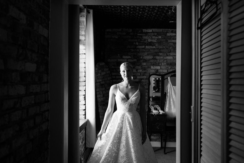 Dramatic black and white bridal portrait in industrial venue hallway.