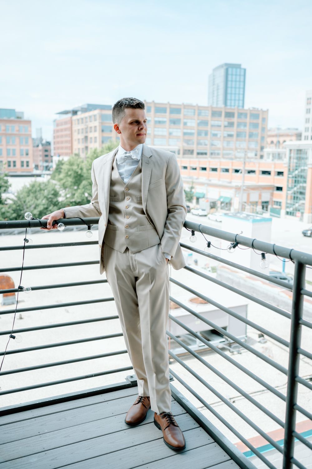 A series of photos showing a person in a light beige suit posing on an urban rooftop terrace.