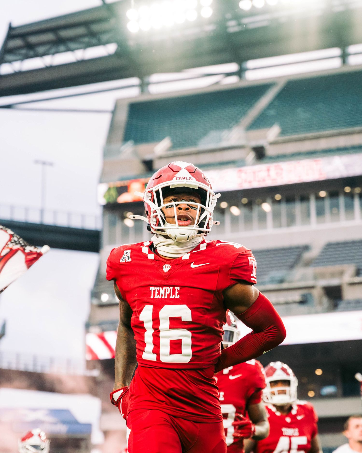 Temple football players in red uniforms run drills during practice at Lincoln Financial Field.