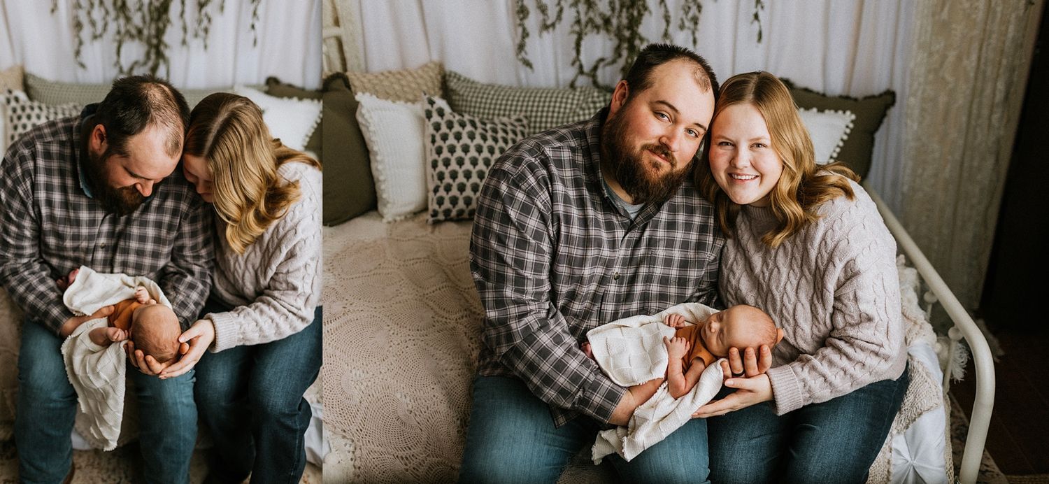 Loving parents in plaid and gray sweaters snuggle their newborn baby in an intimate family portrait.