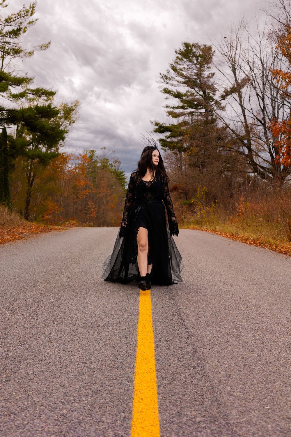 Four sequential photos show figures in black gothic attire posing dramatically on an autumn road with yellow lines.