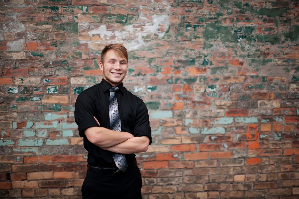 High school senior leaning against brick wall in downtown Duluth MN