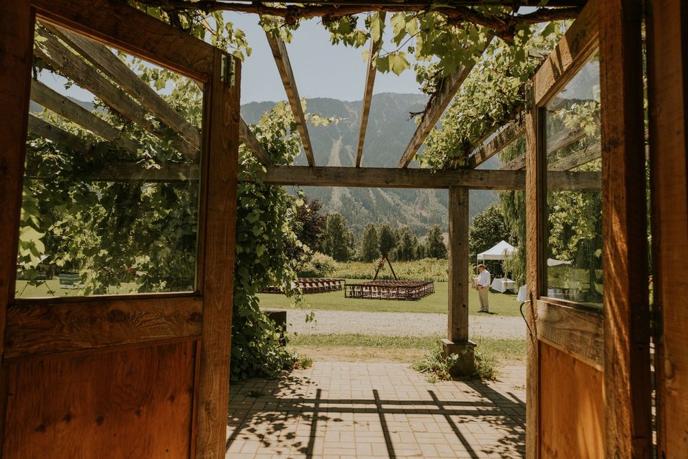 Rustic wooden pergola with mountain views through large windows creating a natural framed backdrop.