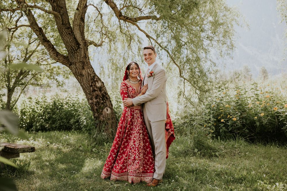 Candid wedding photos captured under weeping willow trees with traditional Indian and Western attire.