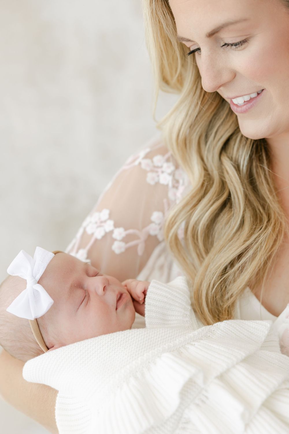 Close-up shots capturing gentle moments with a sleeping newborn in white lace.