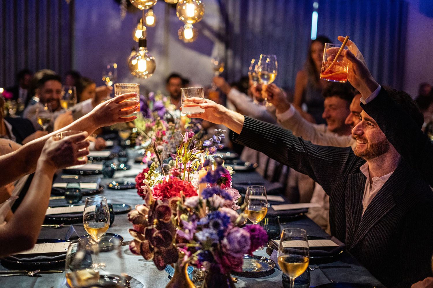 Bruidsgasten proosten met drankjes op het bruidspaar.