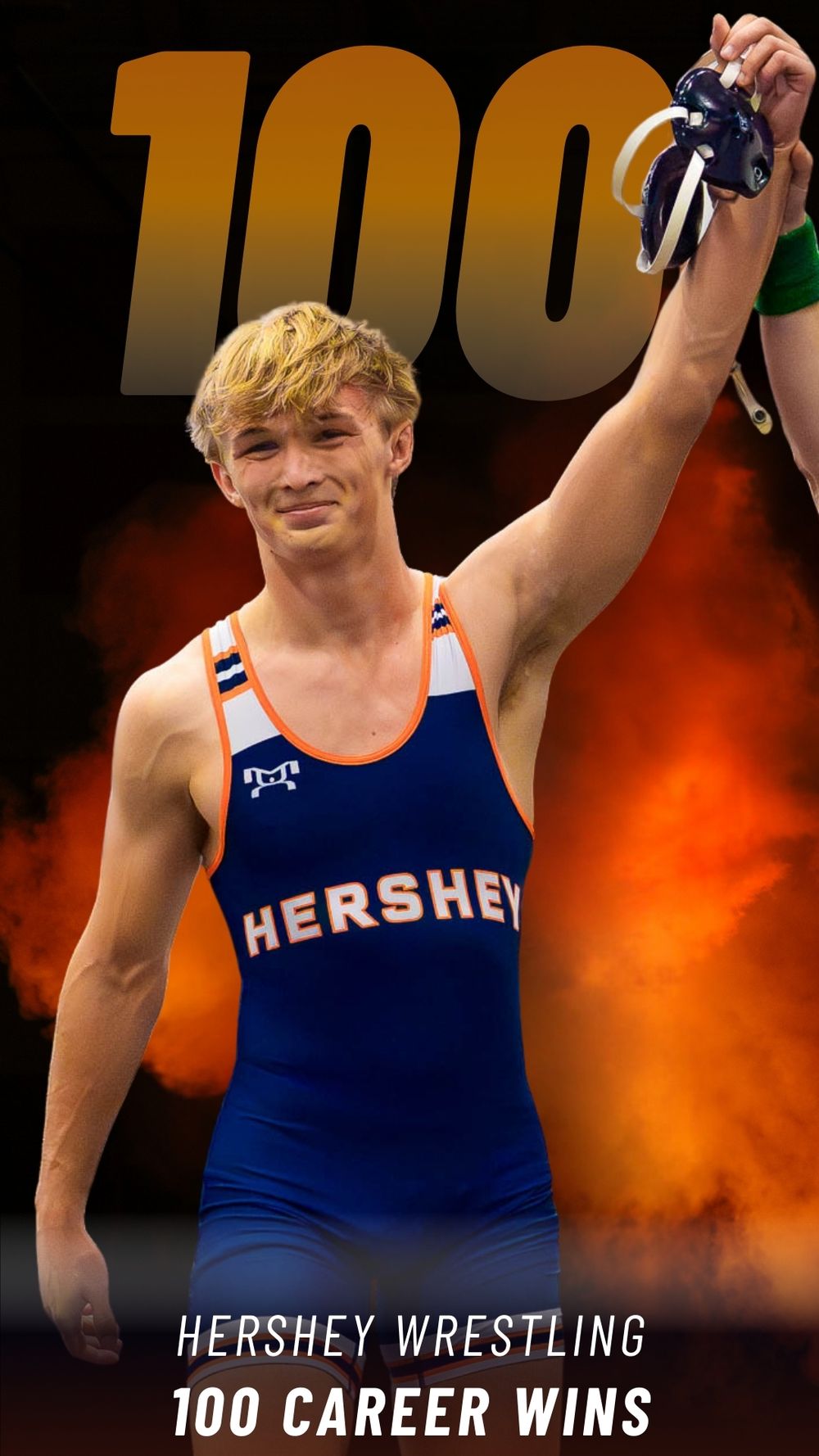 Portrait of Christian Burd, Hershey wrestler, holding up his arm in victory for 100 career wins during the 2025-26 season.