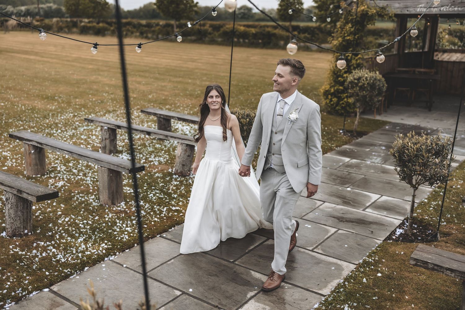 Relaxed wedding photography capturing a married couple walking on a rainy wedding day.