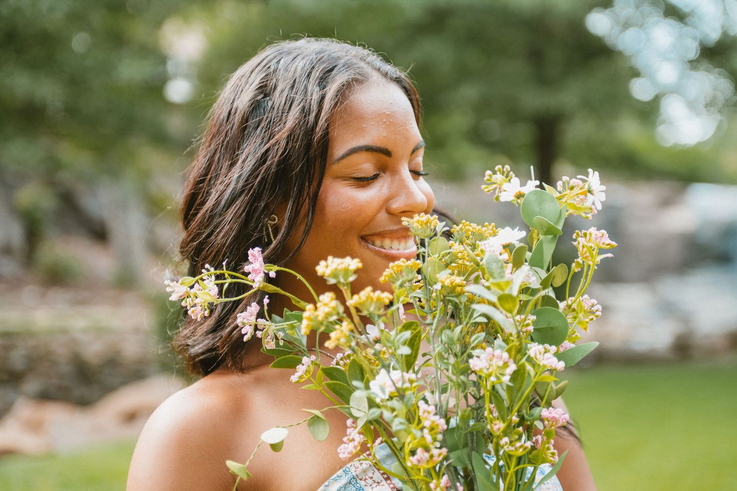 A joyful moment captured in a garden with white spring blossoms and natural sunlight filtering through the trees.