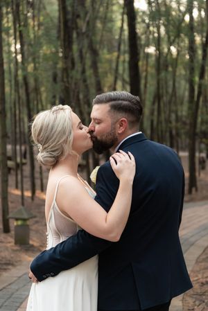 Bride and groom kissing during wedding portraits in forest in Gauteng