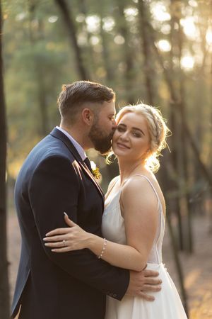Groom kissing bride during wedding portraits in Gauteng with warm, natural light