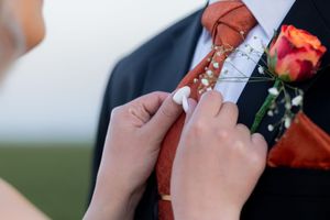 Bride adjusting groom’s tie and boutonniere during wedding preparation in Gauteng