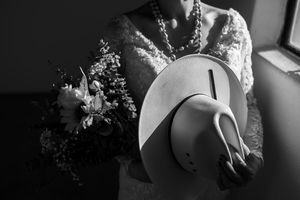 Bride holding hat and bouquet during wedding preparation in Gauteng