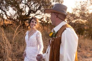 Bride and groom holding hands during sunset wedding portraits in Gauteng